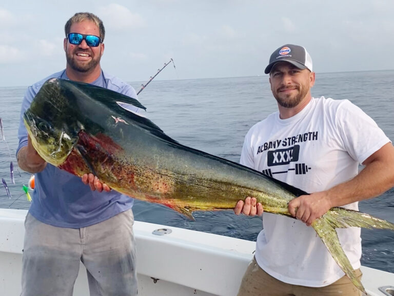 Angler and deckhand proudly display the new Rhode Island state record mahi-mahi from the back deck of a charter boat.